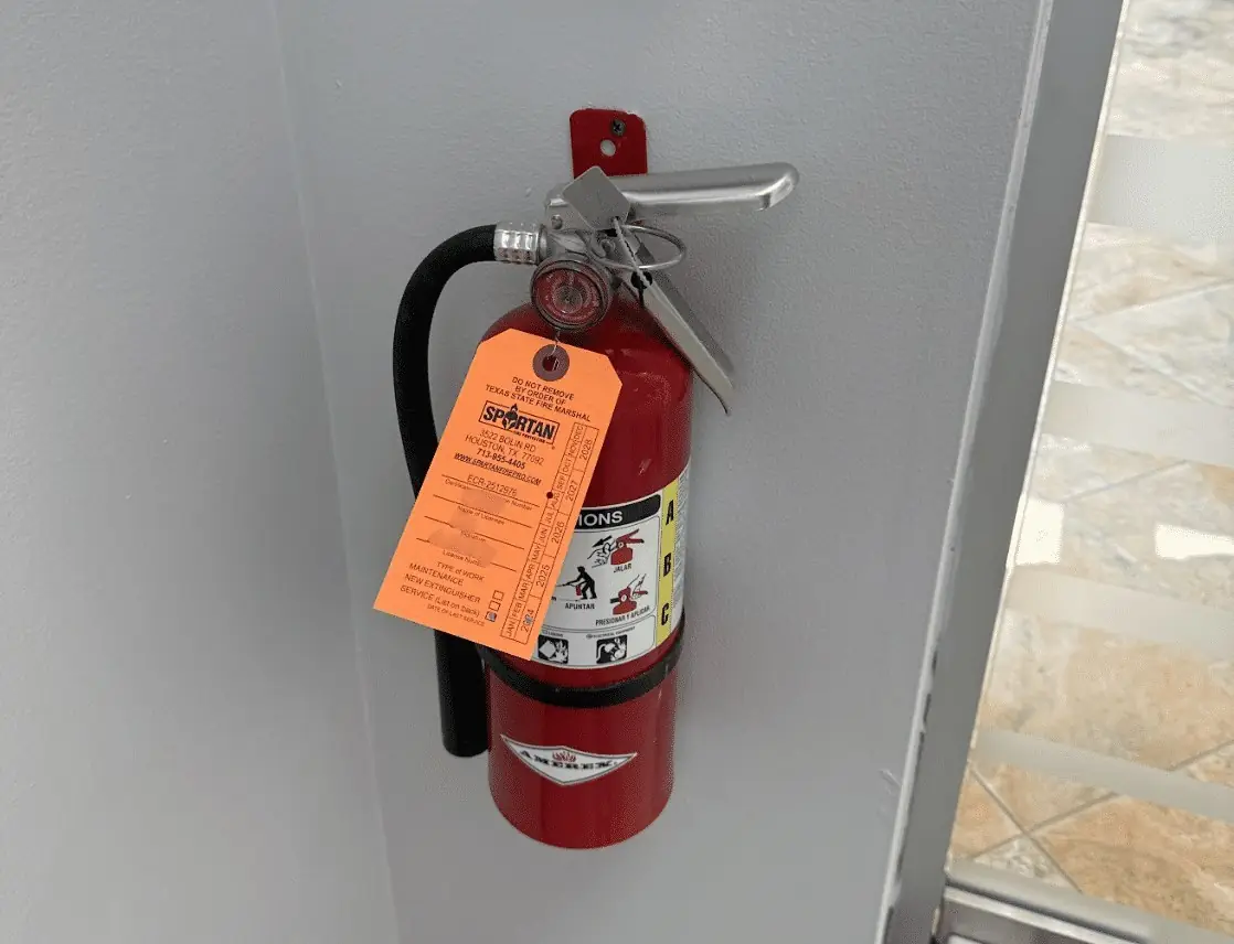 Newly installed fire extinguisher with its inspection tag