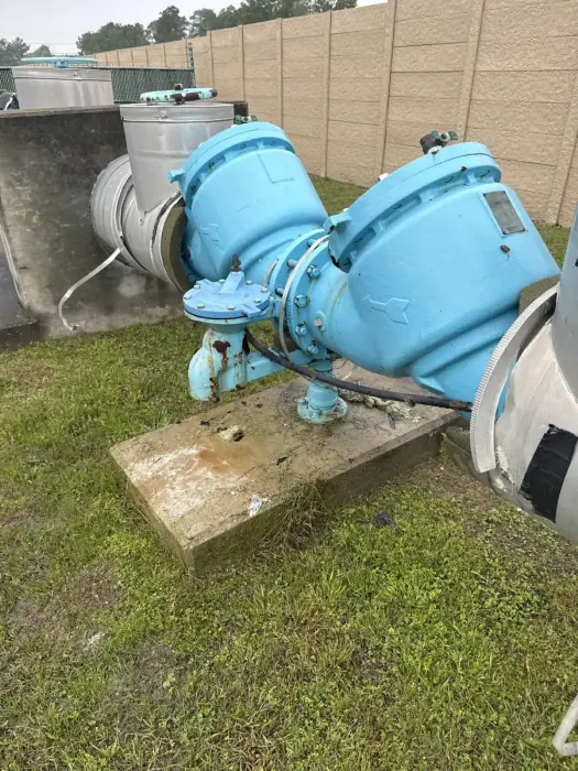Light blue backflow preventer assembly on a concrete pad