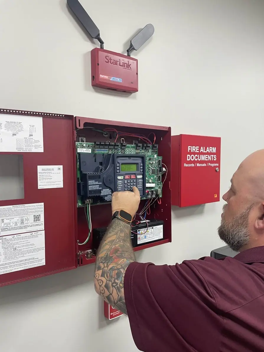 Spartan technician working inside an open fire alarm control panel